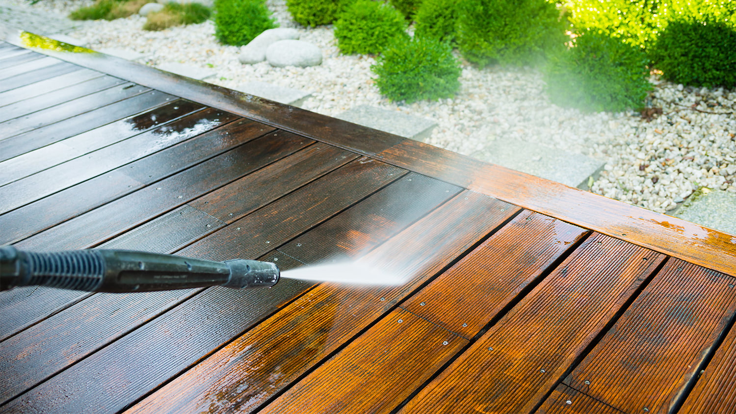 Professional pressure washer cleaning decking